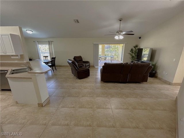 tiled living room with lofted ceiling, sink, plenty of natural light, and ceiling fan