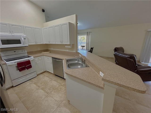 kitchen featuring light tile patterned flooring, white cabinetry, sink, kitchen peninsula, and white appliances