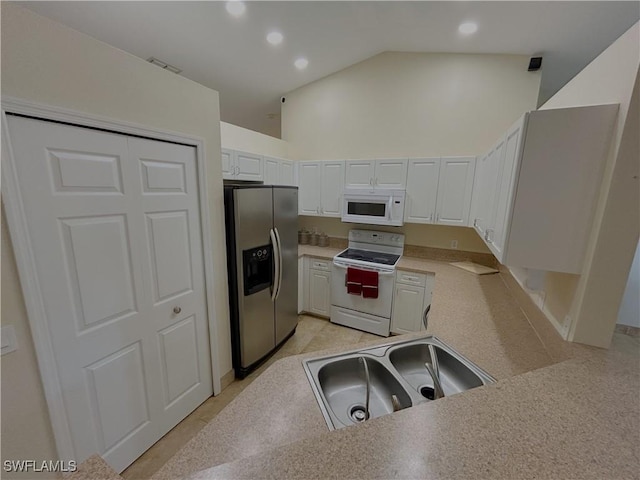 kitchen with sink, white cabinets, light tile patterned floors, kitchen peninsula, and white appliances