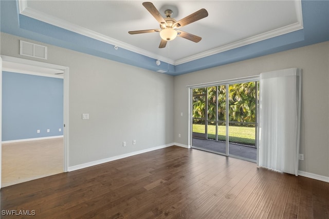 empty room featuring crown molding, ceiling fan, dark hardwood / wood-style flooring, and a raised ceiling