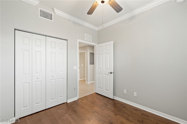 unfurnished bedroom featuring crown molding, dark hardwood / wood-style floors, ceiling fan, and a closet