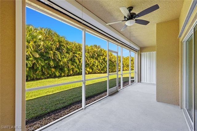 unfurnished sunroom featuring ceiling fan