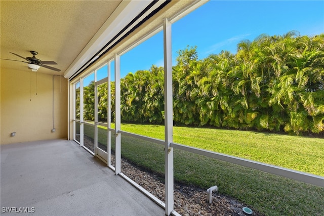 unfurnished sunroom with ceiling fan