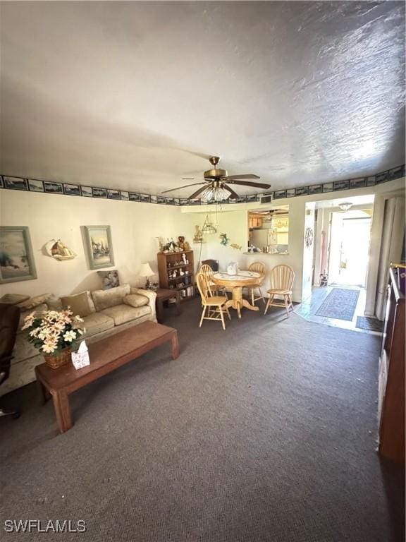 unfurnished living room with a textured ceiling, ceiling fan, and carpet flooring