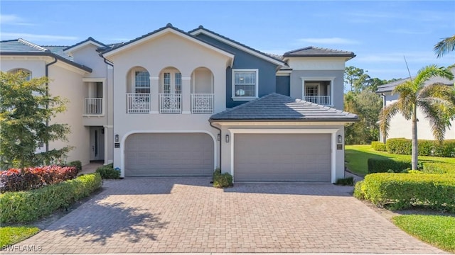 view of front facade featuring a balcony, driveway, and stucco siding