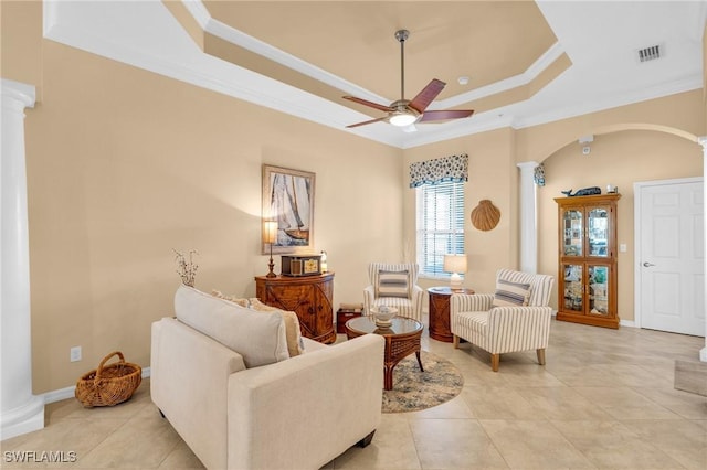 living room with decorative columns, light tile patterned floors, ceiling fan, a raised ceiling, and crown molding