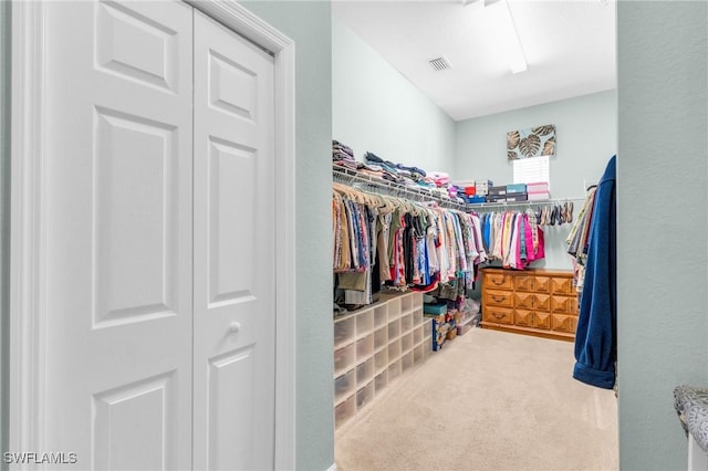 walk in closet featuring visible vents and carpet flooring