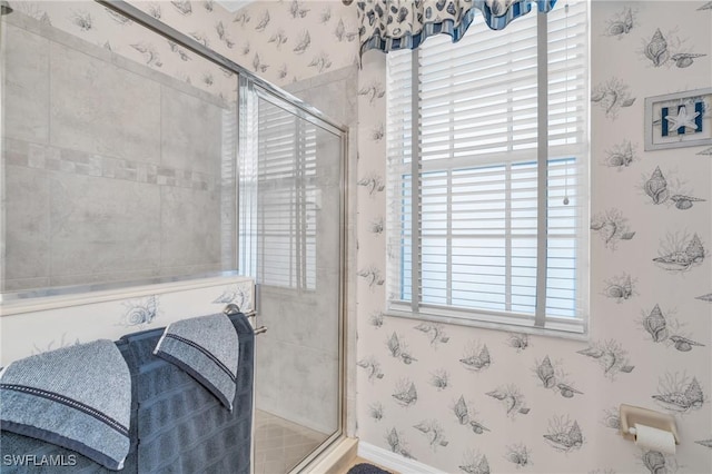 full bathroom featuring wallpapered walls, baseboards, and a shower stall