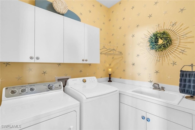 laundry room with cabinets, sink, and washing machine and dryer