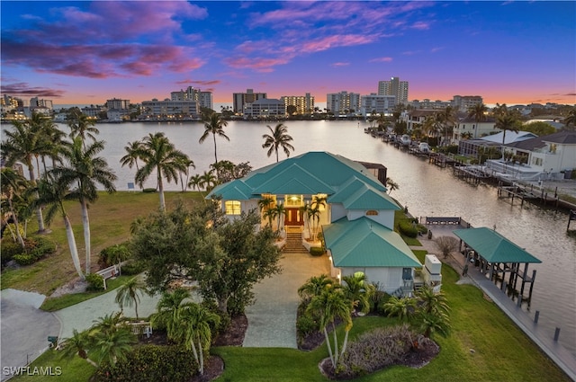 aerial view at dusk featuring a water view