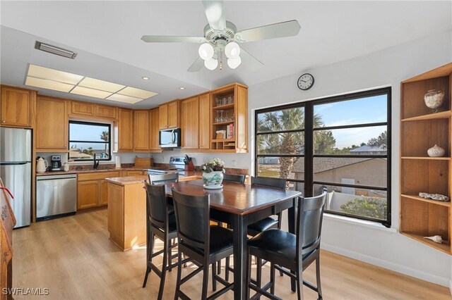 dining space with sink, light hardwood / wood-style flooring, and ceiling fan