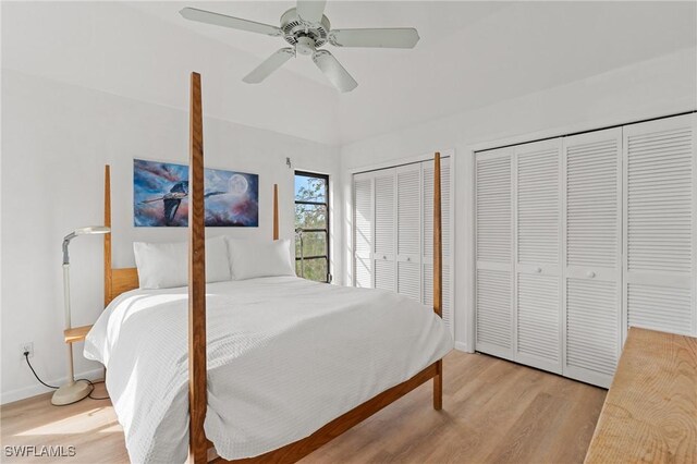 bedroom with ceiling fan, light hardwood / wood-style floors, and two closets