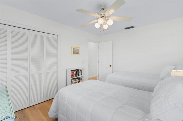 bedroom with ceiling fan, a closet, and light hardwood / wood-style flooring