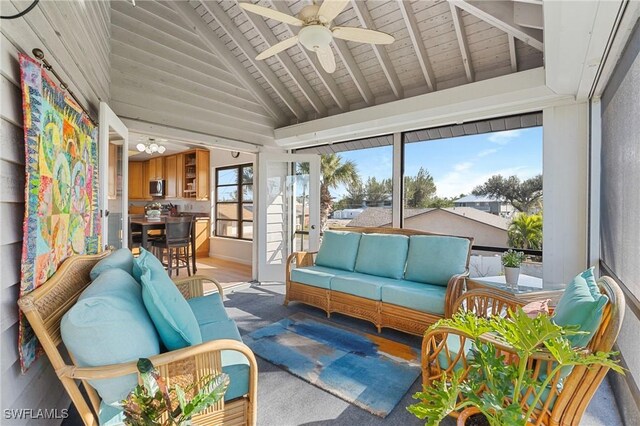 sunroom featuring lofted ceiling with beams, wooden ceiling, and ceiling fan