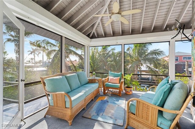 sunroom with vaulted ceiling with beams, ceiling fan, wooden ceiling, and a wealth of natural light