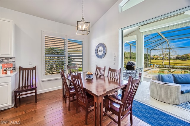 dining area featuring vaulted ceiling and dark hardwood / wood-style floors