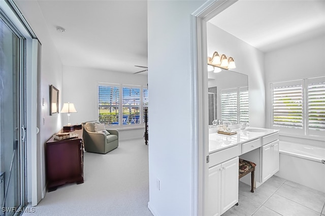 bathroom with vanity, tile patterned flooring, a tub, and a healthy amount of sunlight