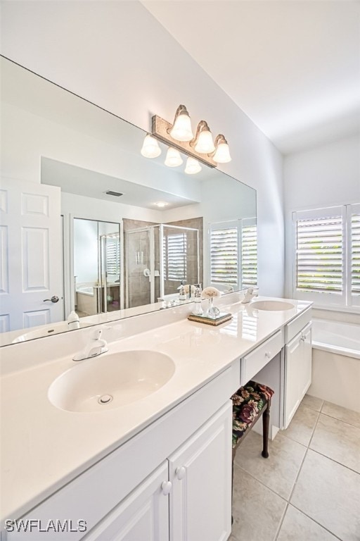 bathroom featuring tile patterned flooring, vanity, and shower with separate bathtub