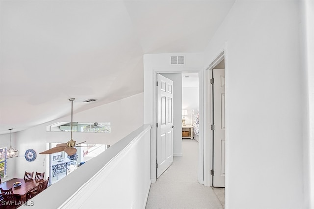 hallway featuring light colored carpet