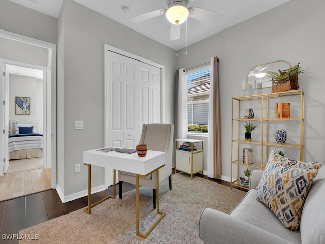 home office with dark hardwood / wood-style floors and ceiling fan