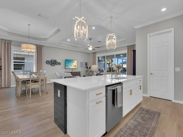 kitchen featuring white cabinetry, sink, decorative light fixtures, and a kitchen island