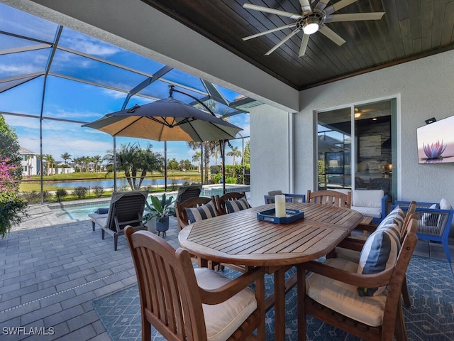 view of patio / terrace with a water view, ceiling fan, a lanai, and outdoor lounge area