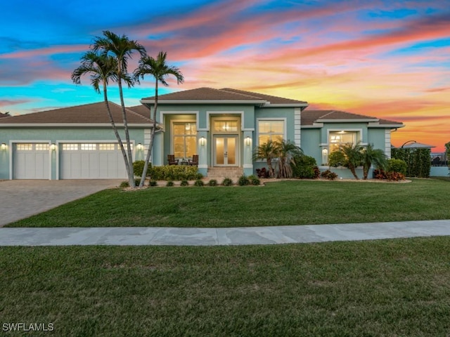 view of front of property featuring a garage and a lawn