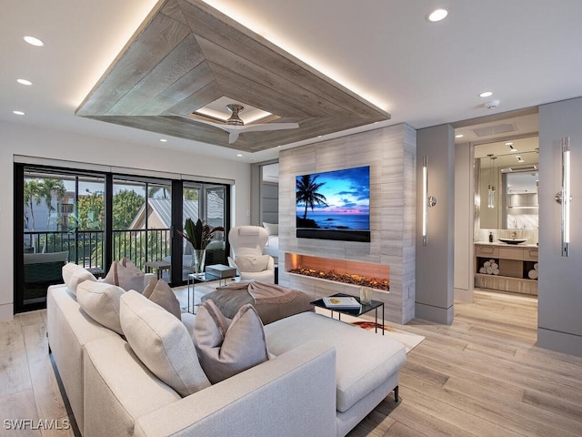 living room featuring ceiling fan and light hardwood / wood-style flooring