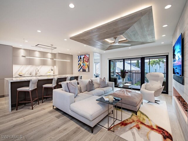 living room featuring sink and light hardwood / wood-style flooring