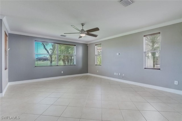 tiled spare room featuring ceiling fan, ornamental molding, and a healthy amount of sunlight