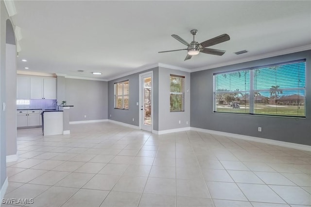 unfurnished living room with light tile patterned flooring, ceiling fan, ornamental molding, and sink