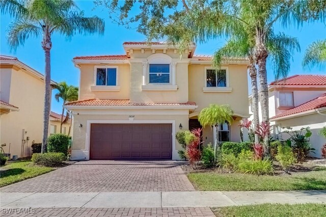 1654 Double Eagle Trl, Naples, FL 34120 - mediterranean / spanish-style house with a tiled roof, decorative driveway, a garage, and stucco siding