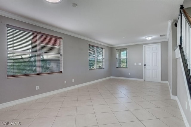 unfurnished room with ornamental molding and light tile patterned floors