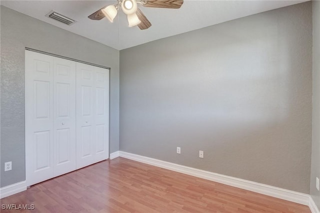 unfurnished bedroom featuring ceiling fan, light hardwood / wood-style floors, and a closet