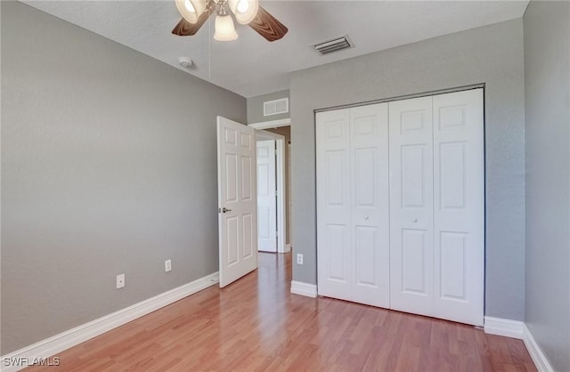 unfurnished bedroom featuring light hardwood / wood-style flooring, a closet, and ceiling fan