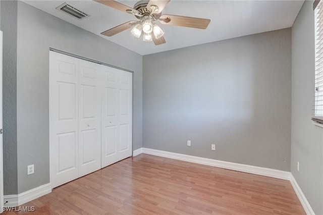 unfurnished bedroom with ceiling fan, a closet, and light wood-type flooring