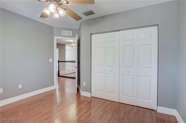 unfurnished bedroom with ceiling fan, light hardwood / wood-style floors, and a closet