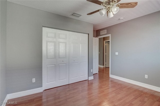 unfurnished bedroom with ceiling fan, light hardwood / wood-style floors, and a closet