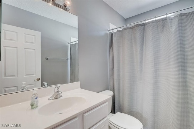 bathroom with vanity, curtained shower, and toilet