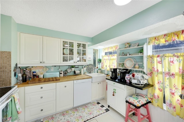 kitchen with white cabinetry, white appliances, wood counters, and a textured ceiling