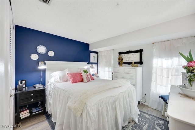 bedroom featuring a textured ceiling and light wood-type flooring