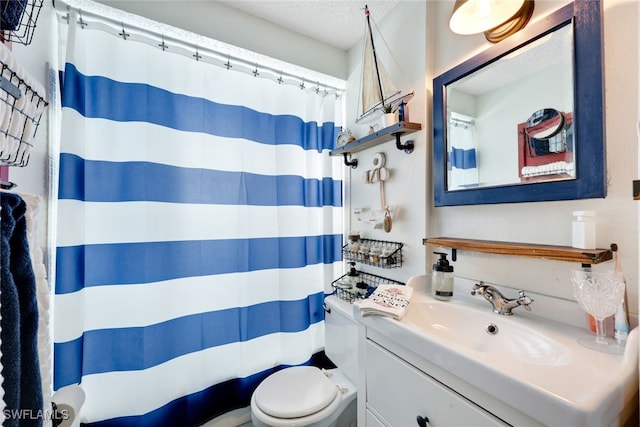 bathroom featuring vanity, toilet, and a textured ceiling