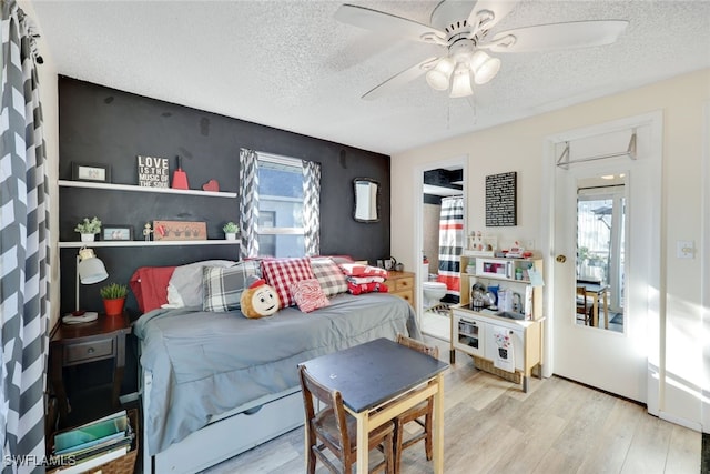 bedroom featuring multiple windows, hardwood / wood-style floors, and a textured ceiling