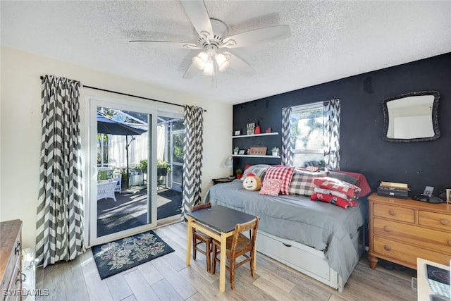 living room featuring ceiling fan, a textured ceiling, and light hardwood / wood-style floors