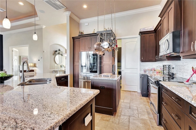 kitchen featuring appliances with stainless steel finishes, pendant lighting, sink, a center island, and light stone countertops