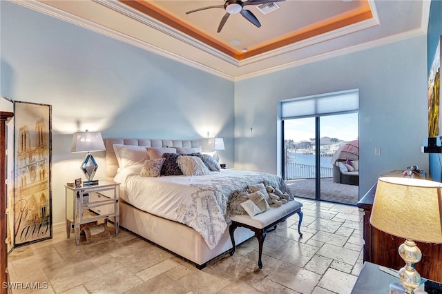 bedroom with ornamental molding, a water view, access to outside, and a tray ceiling