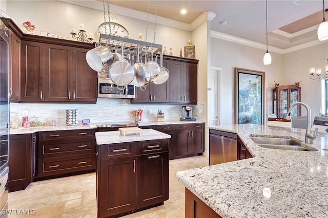 kitchen with sink, light stone counters, a center island with sink, pendant lighting, and stainless steel appliances