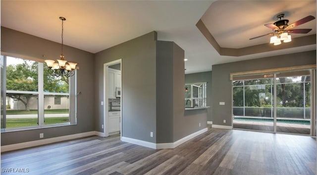 interior space featuring hardwood / wood-style flooring and ceiling fan with notable chandelier