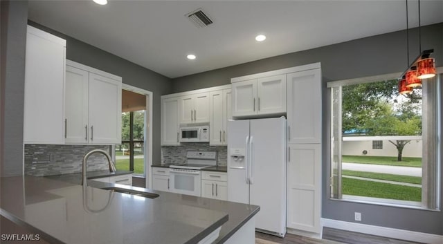 kitchen featuring white cabinetry, white appliances, and decorative light fixtures