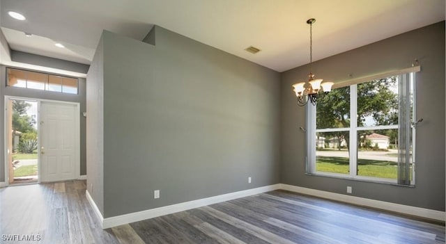 unfurnished dining area with an inviting chandelier and wood-type flooring